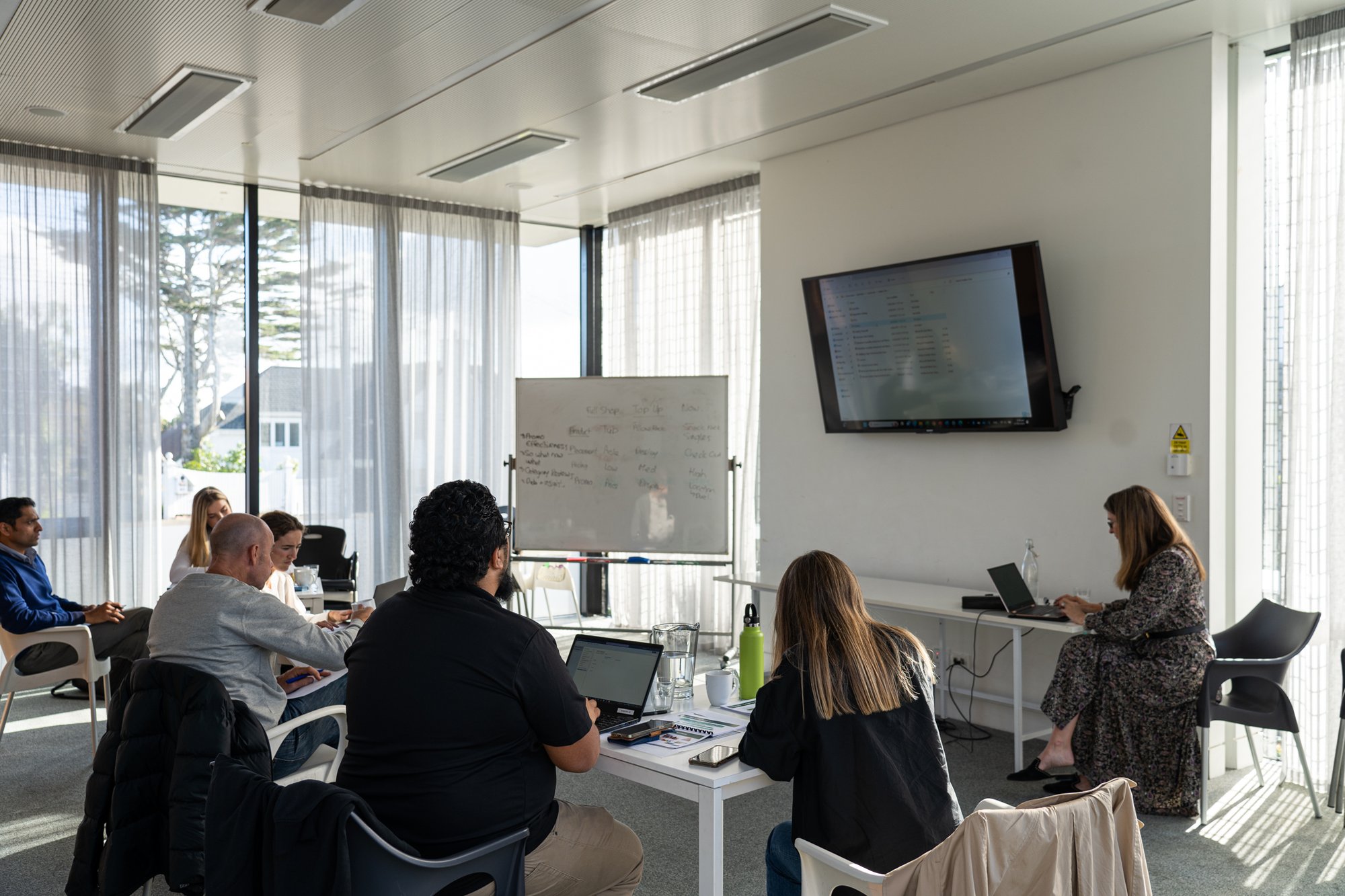 Team in a meeting room watching screen