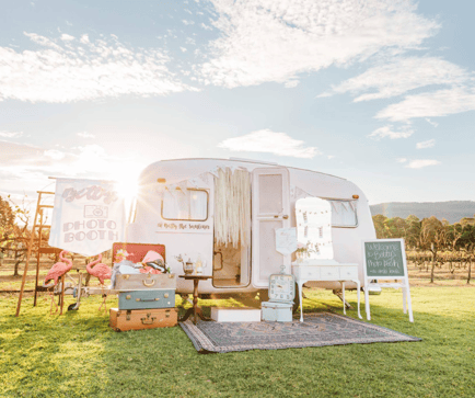 Pink vintage Sunliner caravan set up as a photo booth with suitcases and vanity table, bookable on SpacetoCo