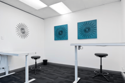 Empty stand-up desks with stools in a minimal white room at MKG Open Spaces, bookable on SpacetoCo