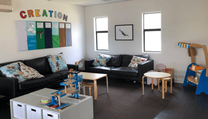 Encounter Christian Centre toddler play space with soft couches, a creation-themed wall display and children's toys, book it via SpacetoCo