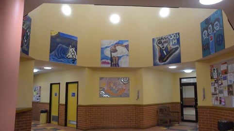 Atwell Hall foyer with curved yellow walls displaying colourful community artwork, bookable on SpacetoCo